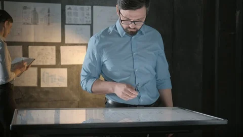 Architect working with interactive panel, colleague is standing behind Video stock 121971775