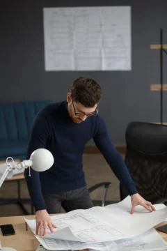 Architect working in office with blueprints.Engineer inspect architectural plan Stock Photos