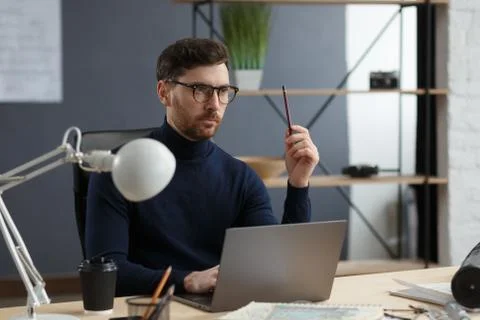 Architect working in office with laptop.Engineer thinks over architectural plan Stock Photos