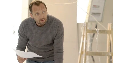 Architect working on the project and looks very busy, steadycam shot Video stock 76517163