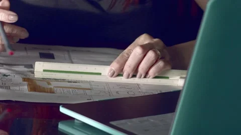 Architect working on project blueprint plans at her office desk Stock Footage 227279431