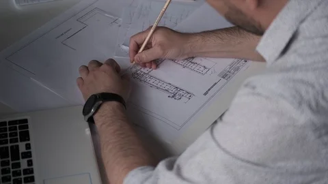 Architect works with blueprints and documents at his desk. back view. Stock Footage 107768447
