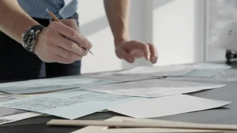 The architect works with drawings on the table. Close-up, only hands Stock Footage 256694147