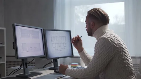 Architect works in loft using drawing board. Workplace of young and serious Stock Footage 143340878