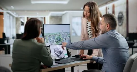 Architect Works With Team Using BIM Software For 3D Building Design. Stock Photos