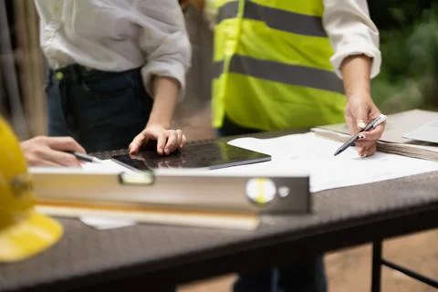 Architector and engineers with draft plan of building and tablet computer Foto stock