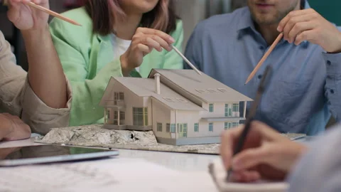 Architects and designers working on design of house layout in creative office Stock Footage 164983233