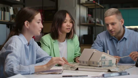 Architects and designers working on design of house layout in creative office Stock Footage 164983526