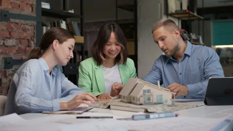 Architects and designers working on design of house layout in creative office Stock Footage 164984174