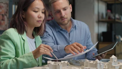 Architects and designers working on design of house blueprint in creative office Stock Footage 164984573