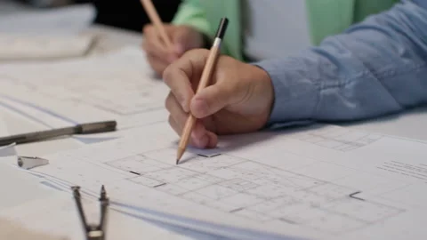 Architects and designers working on design of home blueprint in creative office Stock Footage 164984678