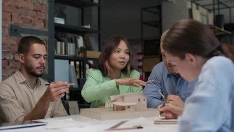 Architects and designers working on design of house layout in creative office Stock Footage 164984987