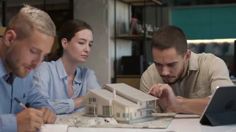Architects and designers working on design of house layout in creative office Stock Footage 164985765