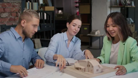 Architects and designers working on design of house layout in creative office Stock Footage 164986142