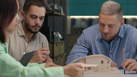 Architects and designers working on design of house layout in creative office Stock Footage 164986425