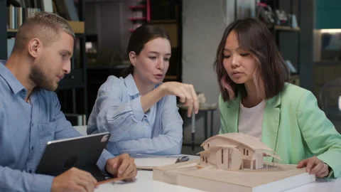 Architects and designers working on design of house layout in creative office Stock Footage 164986516