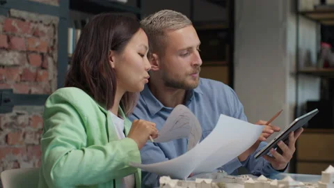 Architects and designers working on design of house blueprint in creative office Stock Footage 164991379