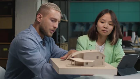 Architects and designers working on design of house layout in creative office Stock Footage 164992865