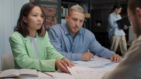 Architects and designers working on design of house blueprint in creative office Stock Footage 164992923
