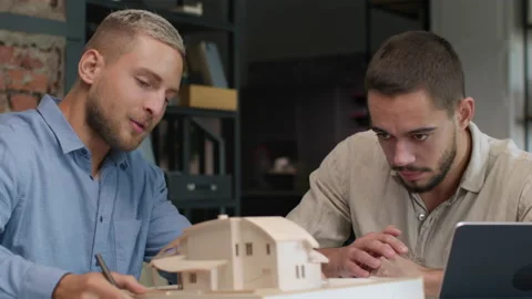 Architects and designers working on design of house layout in creative office Stock Footage 164993654