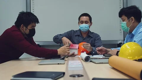 Architects and engineers wearing protective masks working together in a office. Stock Footage 142303683