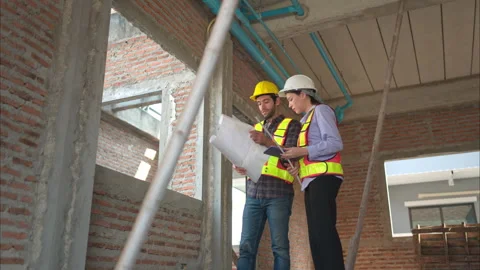 Architects and engineers work together to assess the residential home Stock Footage 308912997