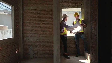 Architects and engineers work together to assess the residential home Stock Footage 308914454