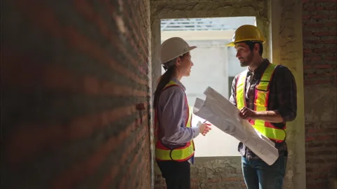 Architects and engineers work together to assess the residential home Stock Footage 308927481