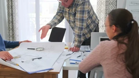 Architects and manager arguing over blueprints in office meeting Stock Footage 316045244