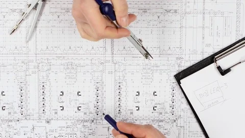Architects are sitting at the table analyzing the drawing. Close up Stock Footage 73676987
