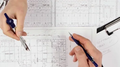 Architects are sitting at the table analyzing the drawing. Close up Stock Footage 73677502