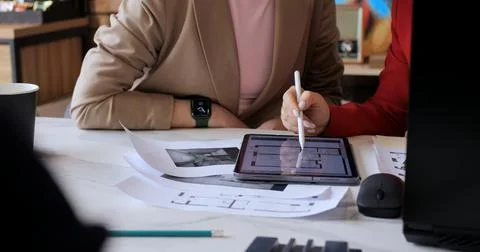 Architects discussing layout on digital tablet, focusing on floor plan details Stock Photos