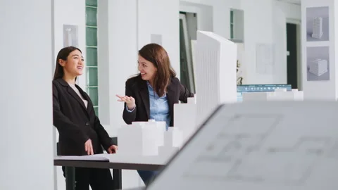 Architects doing high five gesture after finishing blueprints Stock Footage 262997763
