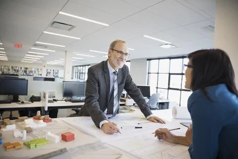 Architects drafting blueprints near model Foto stock