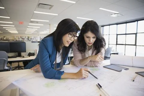 Architects drafting blueprints in office Stock Photos