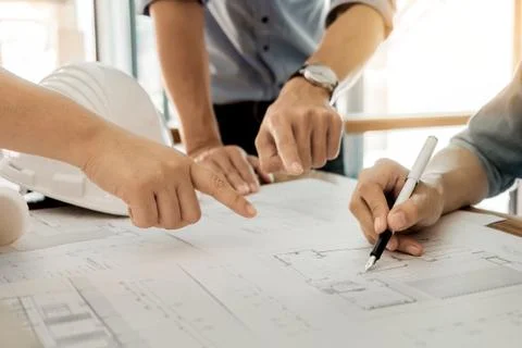 Architects engineer discussing at the table with blueprint - Closeup on hands Stock Photos