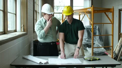 Architects going over plans inside building under construction Stock Footage 49082738