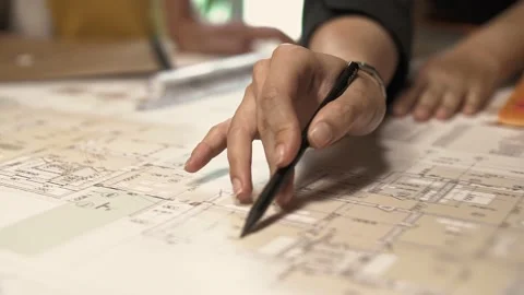 Architect's hand draws a line with a pencil on a project plan with calculations Stock Footage 223101711