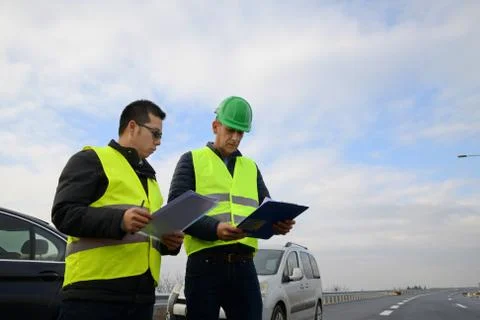 Architects looking at plans, having a discussion at construction site Fotos Stock