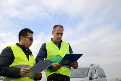 Architects looking at plans, having a discussion at construction site Foto stock