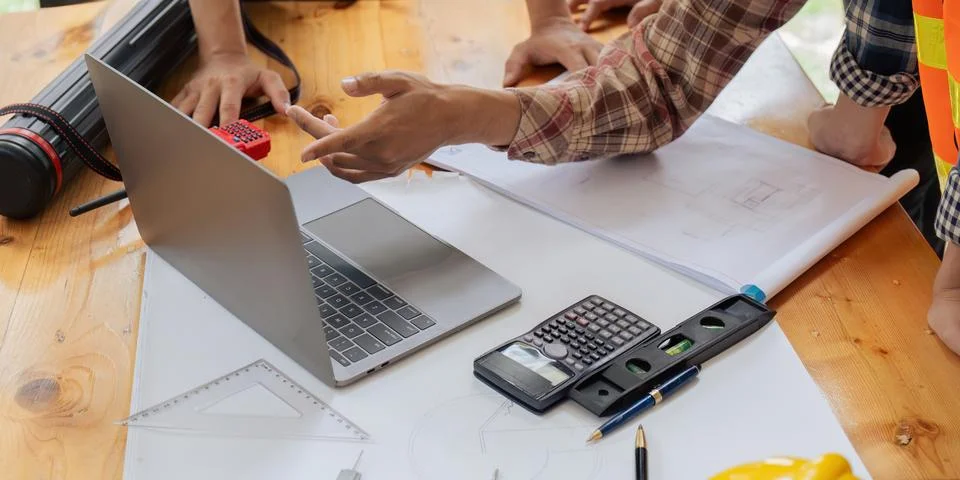 Architects or engineers write a draft of the construction project on the Stock Photos