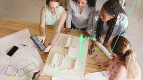 Architects picking up tablet and pointing at model, animated green charts rising Stock Footage 333233195