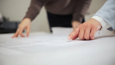 Architects pointing at architectural plans during discussion Stock Footage 326233805