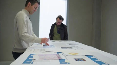 Architects review project plans blueprint meeting room team work workplace Stock Footage 331563313