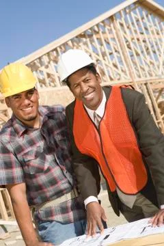 Architects Standing In Front Of Framework With Blueprint Stock Photos
