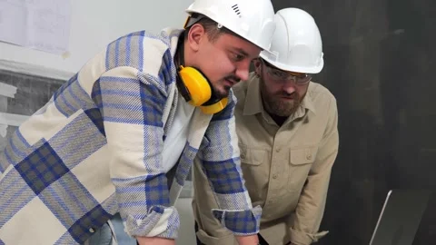 Architects study the drawings on a laptop when building an apartment in a house Stock Footage 235541302