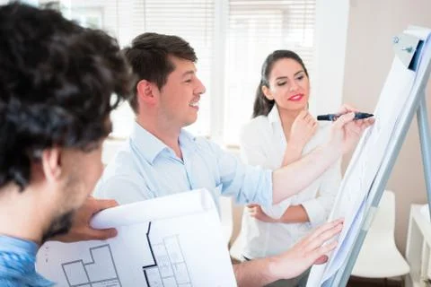 Architects talk about construction plans at flipchart Stock Photos