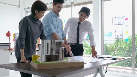 Architects team are working on paper blueprint and building model. Stock-Footage 106670104