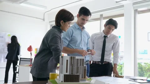 Architects team are working on paper blueprint and building model. Video stock 108675275