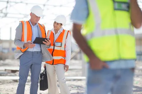 Architects using digital tablet at construction site Stock Photos